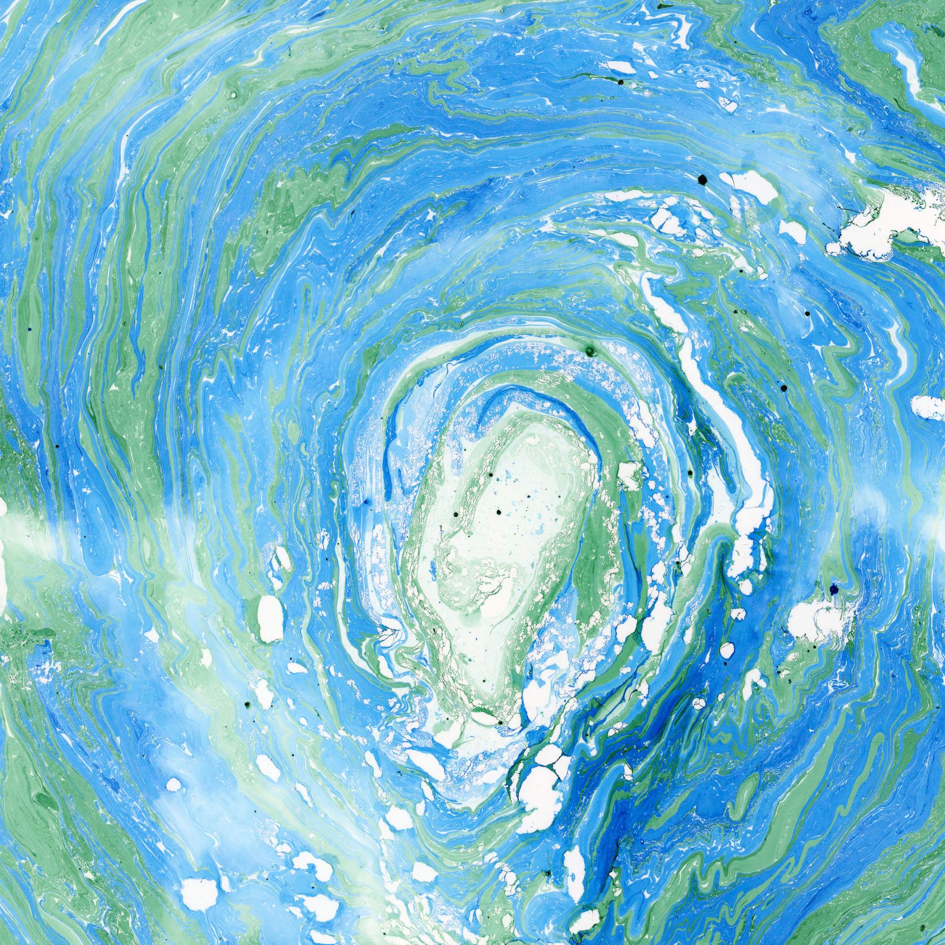 A swirl of marbled blue and green inks on a square sheet of watercolour paper can be seen. The swirls of colour rotate in a circular fashion towards the centre of the paper, suggesting that we are looking into the eye of a storm.