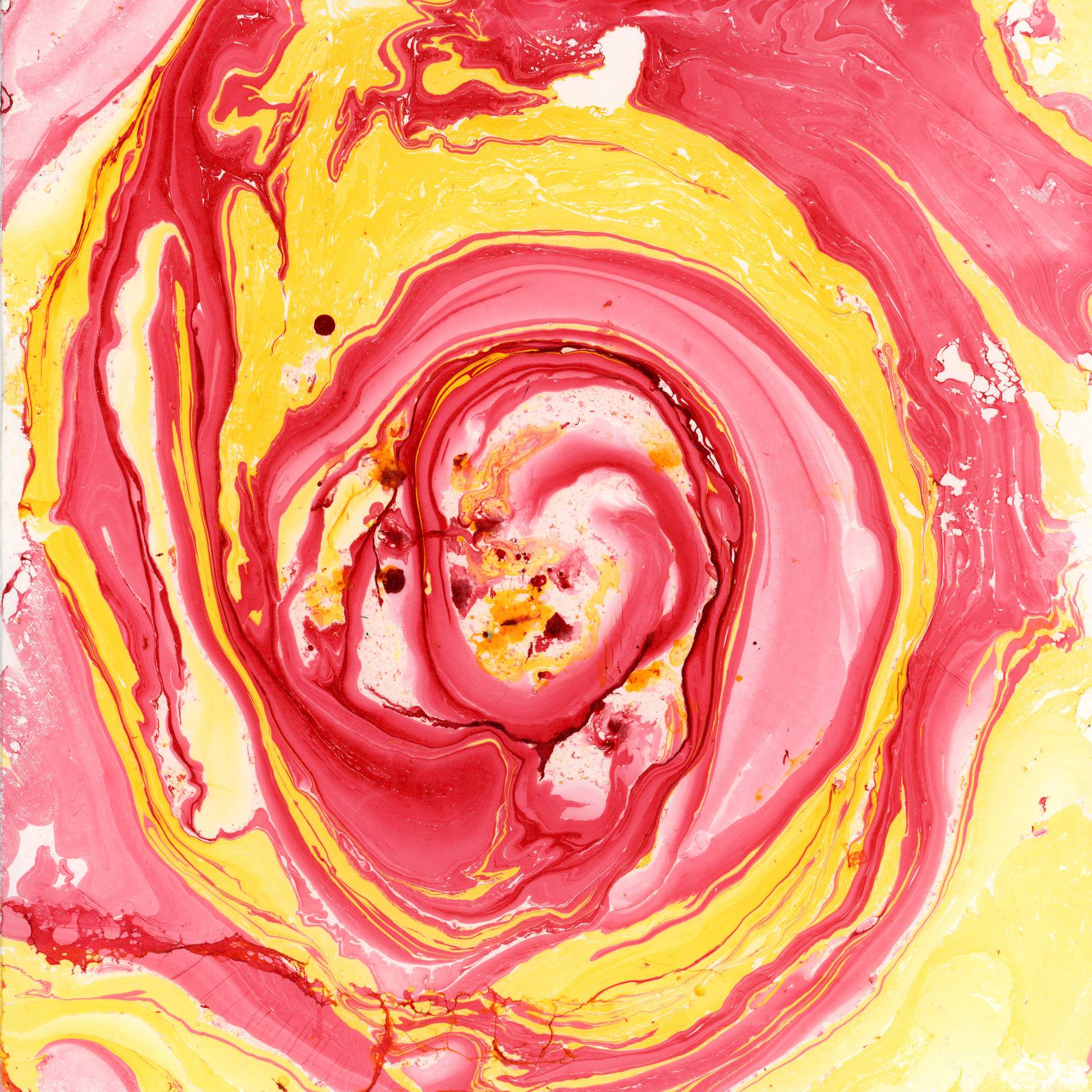 A swirl of marbled red and yellow inks on a square sheet of watercolour paper can be seen. The swirls of colour rotate in a circular fashion towards the centre of the paper, suggesting that we are looking into the eye of a storm.