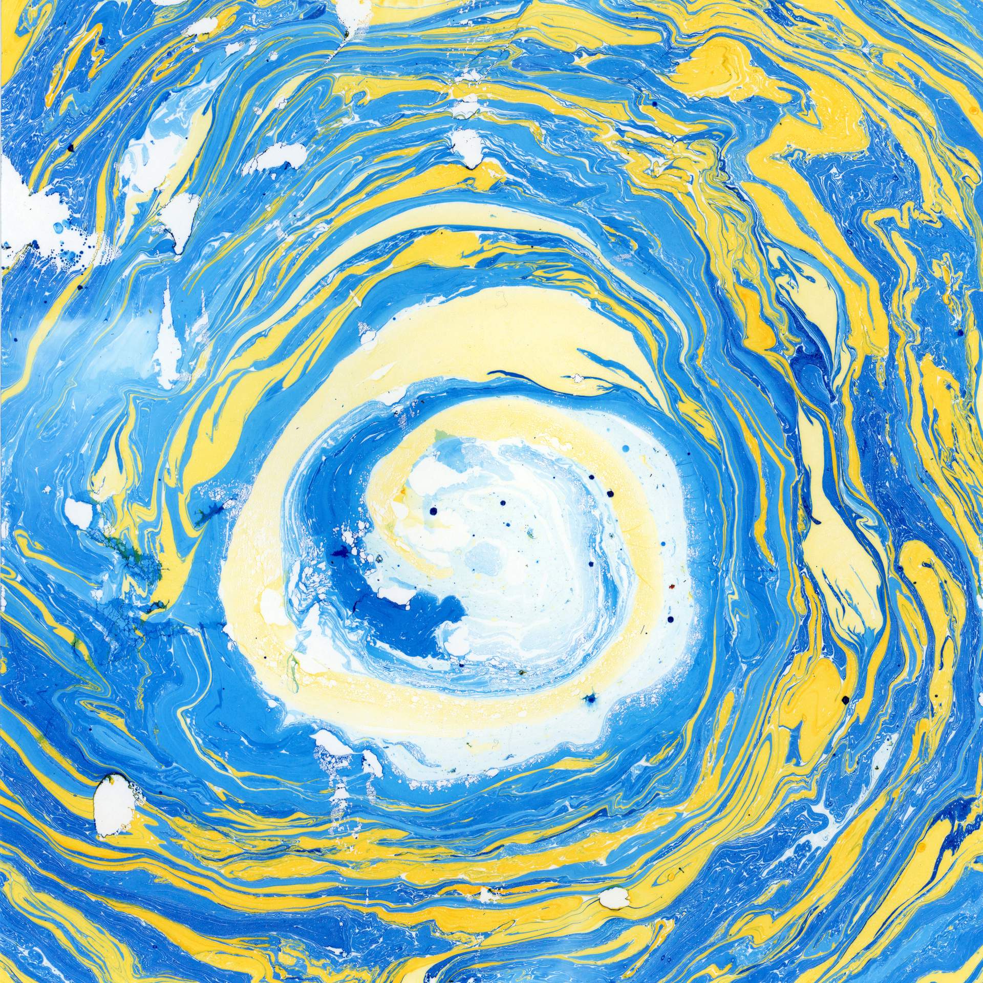 A swirl of marbled blue and yellow inks on a square sheet of watercolour paper can be seen. The swirls of colour rotate in a circular fashion towards the centre of the paper, suggesting that we are looking into the eye of a storm.