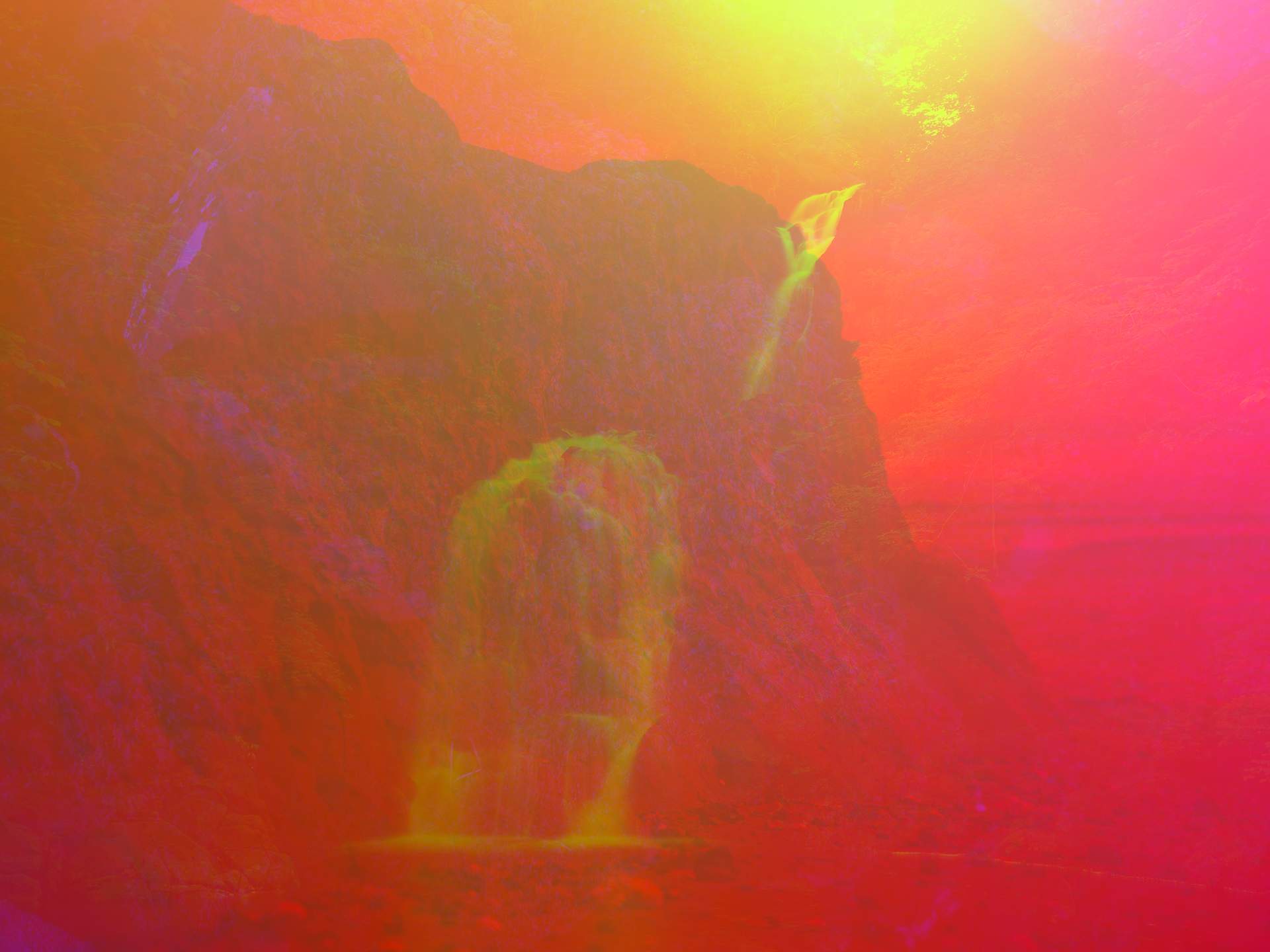 A digital collage, consisting of layers of photographic images in an array of hyper-realistic colours. The image of a waterfall can be seen on top of an image of a small clay land formation by the sea.