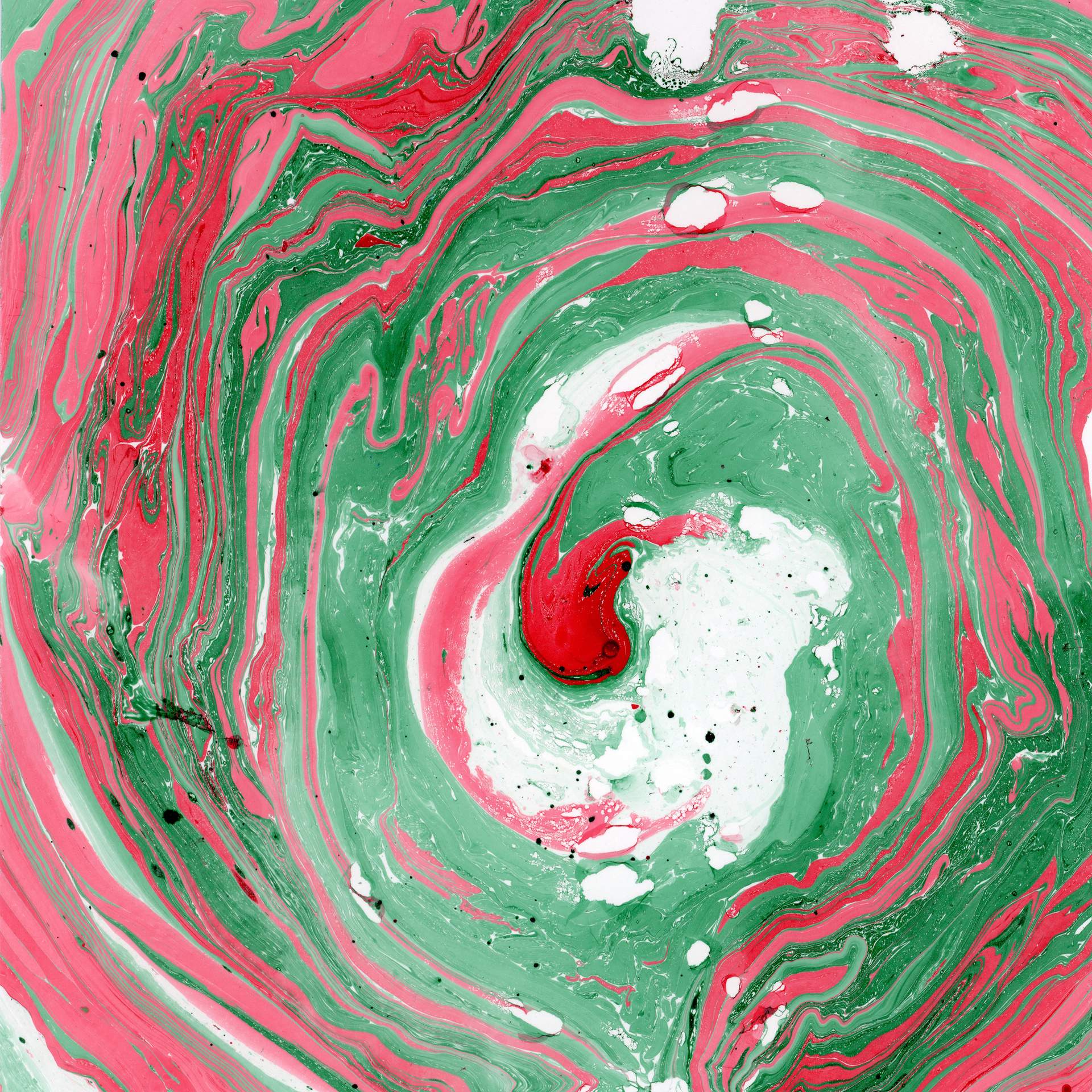 A swirl of marbled red and green inks on a square sheet of watercolour paper can be seen. The swirls of colour rotate in a circular fashion towards the centre of the paper, suggesting that we are looking into the eye of a storm.